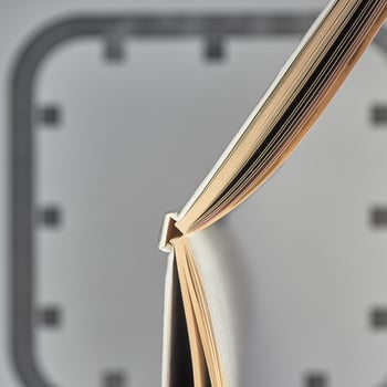 An open book is like the hands of a clock on the background of dial in blur. Open book and clock face. photo