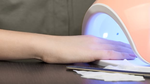 Gel Polish at home. Hand in a glowing UV lamp. photo