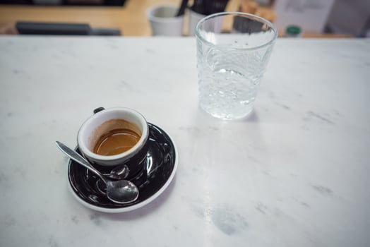 coffee mug and a glass of water on a table photo