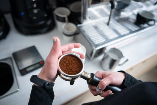 Barista holding portafilter with ground coffee photo