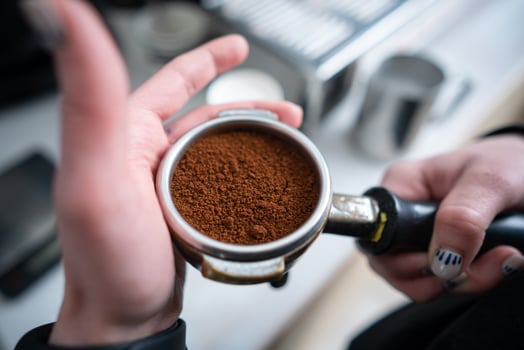 Barista holding portafilter with ground coffee photo