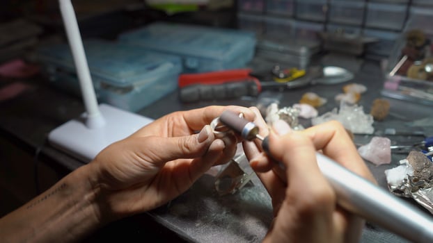 girl master processes the metal plate in the home workshop photo