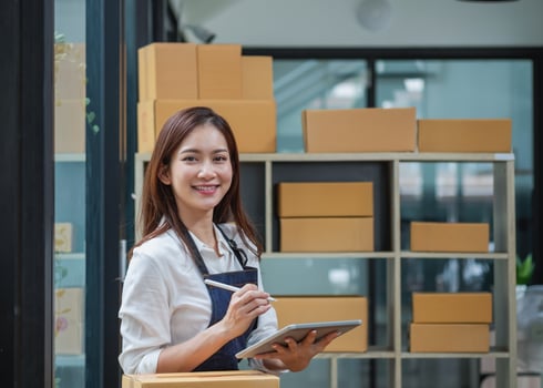 Young businesswoman using a tablet to check online product sales photo