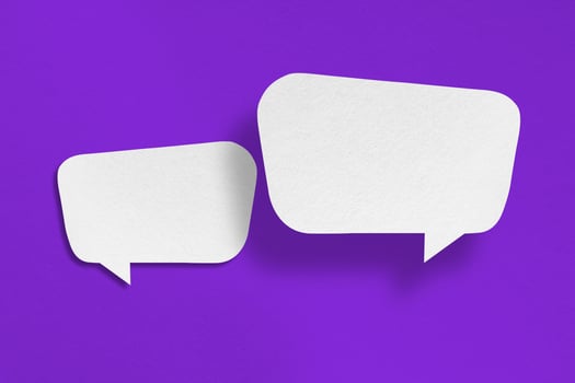 white paper with speech bubbles isolated on purple background photo