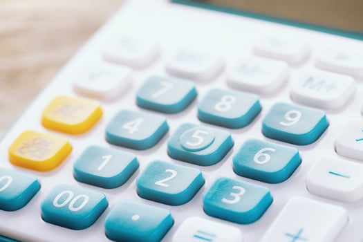 calculator focus at on press button keyboard. calculator colors blue yellow and white on wood table. concept calculate account finance photo