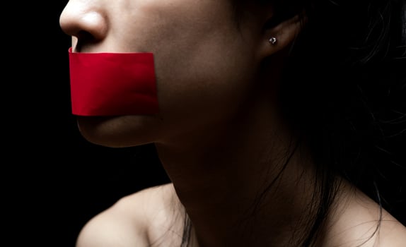 Concept on the topic of freedom of speech, censorship, freedom of press. International Human Right day. the girl's face is sealed her mouth with red paper photo