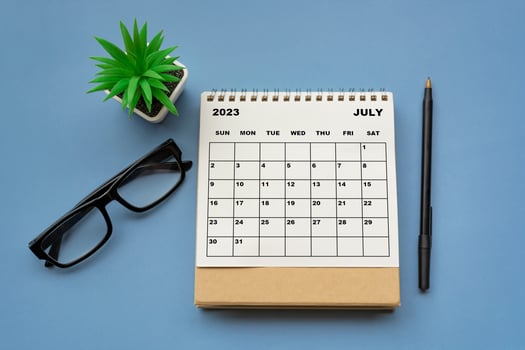 July 2023 desk calendar on blue background. Directly above. photo
