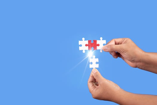 Hands holding jigsaw puzzles piece with clear blue background, success business, solution strategy, teamwork partnership concept photo