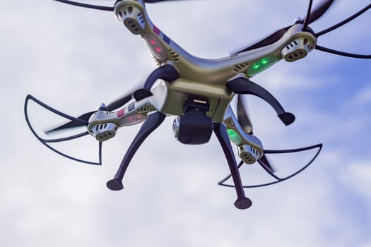flying drone with remote control against blue sky background. photo