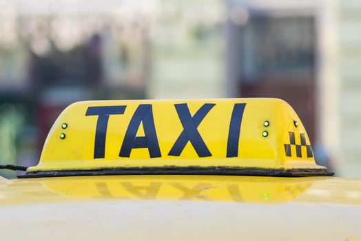 Yellow taxi sign. Taxi car on the street photo