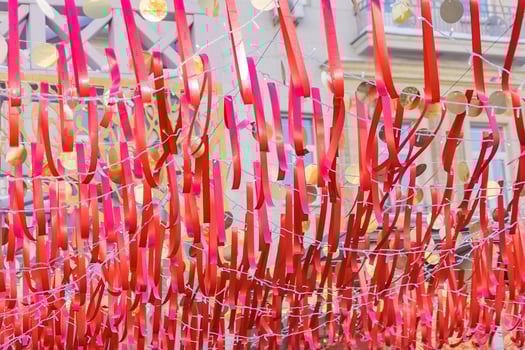 red festive ribbons and gold circles against blue sky. Colorful garland for event decoration photo