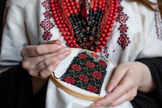 A girl embroiders a traditional Ukrainian vyshyvanka pattern photo