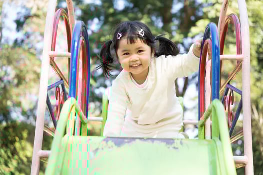 Cute asian girl play on school or kindergarten yard or playground. Healthy summer activity for children. Little asian girl climbing outdoors at playground. Child playing on outdoor playground. photo