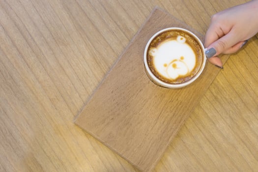 Background of beautiful woman hold cup of coffee on the wood table. photo