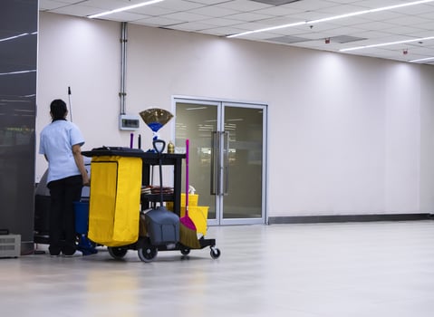 Janitorial car cleaning equipment with warning signs cleaning in process the floor in the building and the maid is working photo