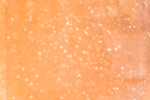 Bokeh abstract texture. Beautiful christmas background in orange colors. Defocused photo