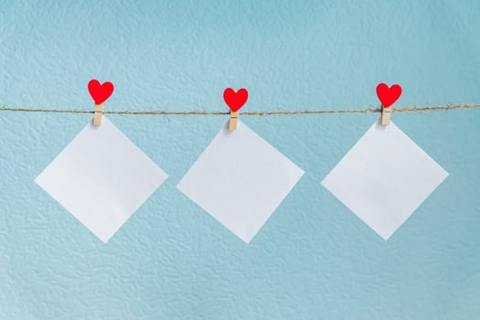 Blank cards on pins with red hearts. Mockup for text and blue background for Valentines Day greetings photo