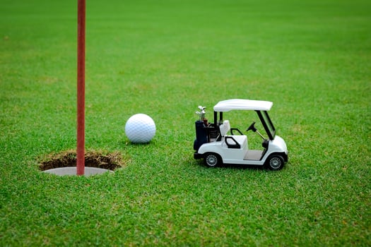 Small golf car figure on green photo