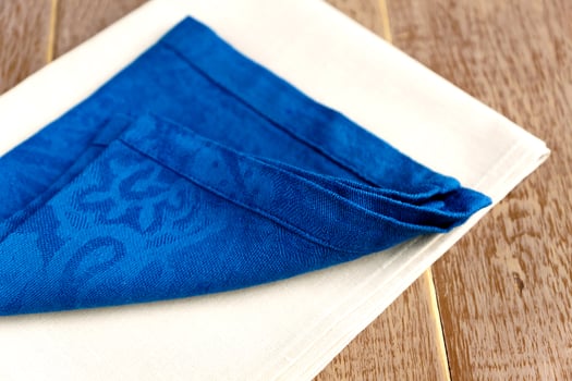 close up of cloth napkins of beige and blue colors on rustic wooden background. photo