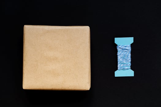 Handcrafted gift box wrapped in Craft paper with blue ribbon and bow photo