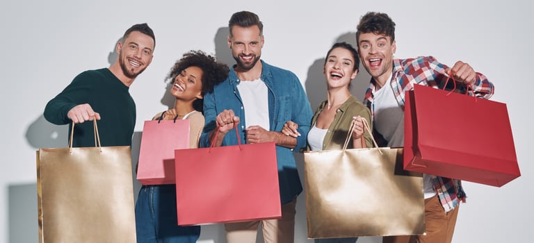 Group of young beautiful people in casual clothing carrying shopping bags and smiling photo