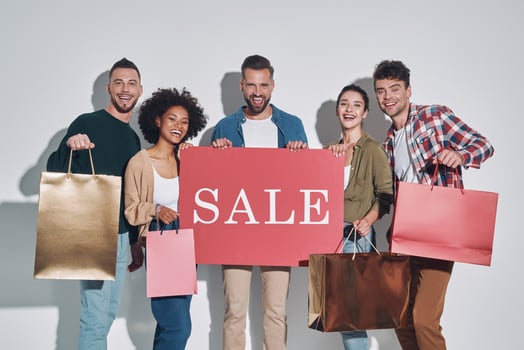 Group of young beautiful people in casual clothing carrying shopping bags and smiling photo