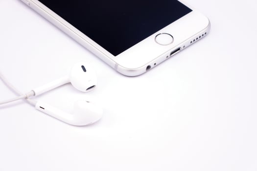 Smart phone  and headphone on white table photo