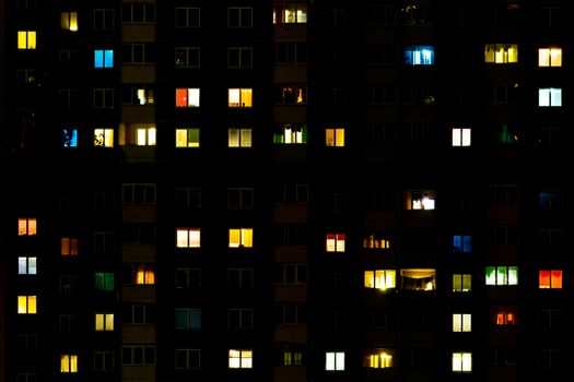 Flat night panorama of multicolor light in windows of multistory buildings. life in big city photo