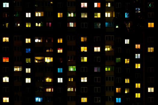 Flat night panorama of multicolor light in windows of multistory buildings. life in big city photo