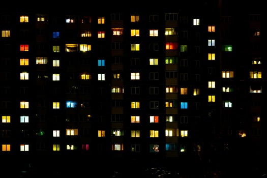 Flat night panorama of multicolor light in windows of multistory buildings. life in big city photo
