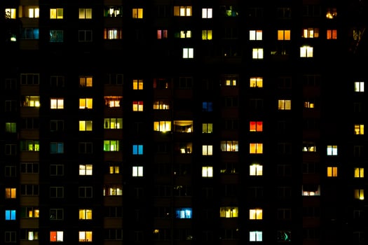 Flat night panorama of multicolor light in windows of multistory buildings. life in big city photo