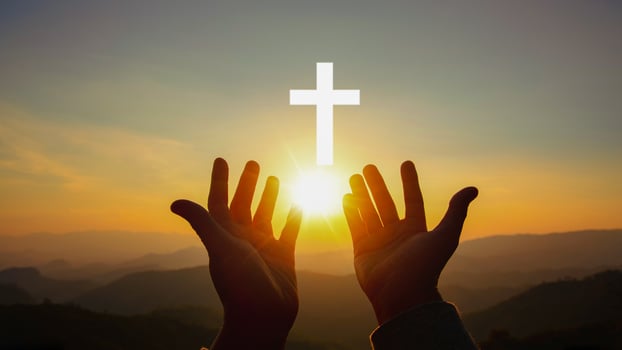 Silhouette of human hands palm up praying and worship of cross, eucharist therapy bless god helping, belief, forgiveness, freedom, hope and faith, christian religion concept on sunset background. photo