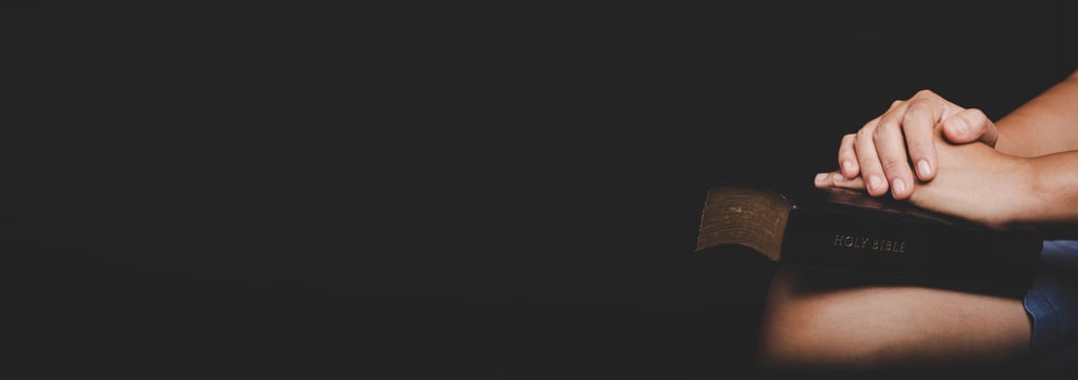 Asian christian woman person pray and worship for thank god in church with black background. photo