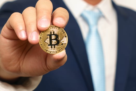 businessman in suit holding a golden bitcoin photo