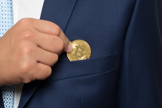 businessman in suit holding a golden bitcoin photo