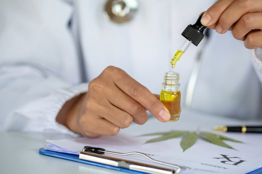 doctor   hand holding bottle of Cannabis oil against Marijuana plant, CBD oil pipette. Cannabis recipe for personal use, legal light drugs prescribe. photo