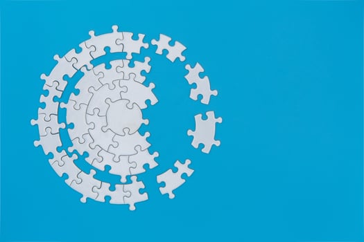 White jigsaw puzzle pieces on a blue background. Problem solving concepts. Texture photo with copy space for text