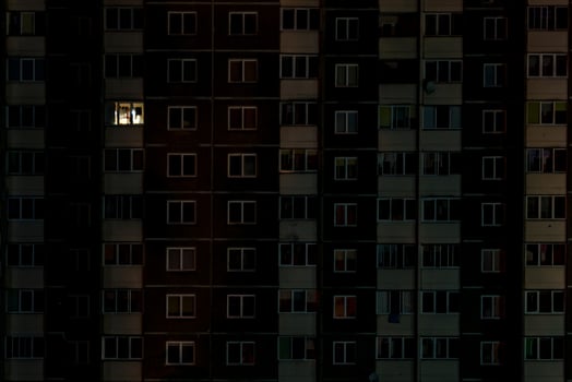 light in a single window. Flat night panorama of multicolor light in windows of multistory buildings. life in big city photo
