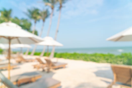 abstract blur umbrella with beach chair for background photo