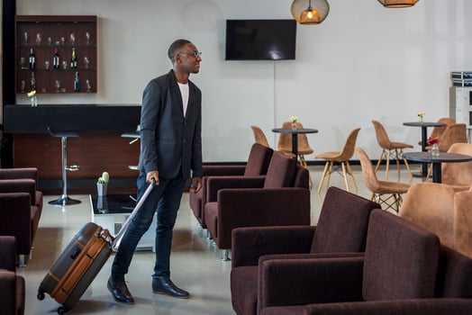 African American businessman in formal wear with luggage is boarding the airplane from airport departure lounge photo