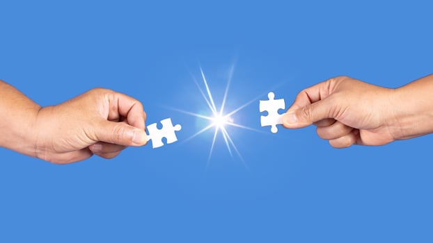 Hands holding jigsaw puzzles piece with clear blue background, success business, solution strategy, teamwork partnership concept photo