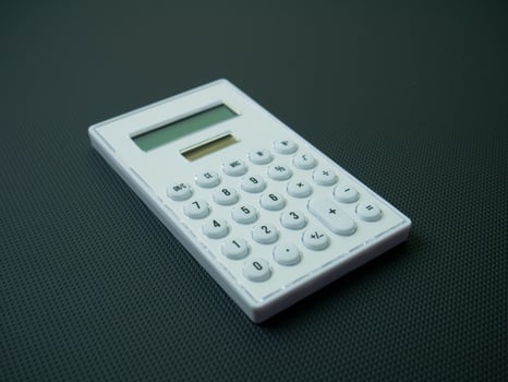 The white calculator on black background for business content. photo