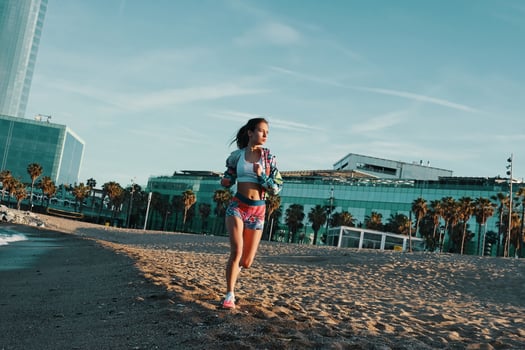 Fit and beautiful. Full length of attractive young woman in sports clothing jogging while exercising outdoors photo