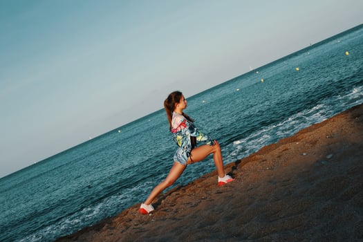 Stretch your limits. Full length of beautiful young woman in sports clothing stretching while warming up outdoors photo