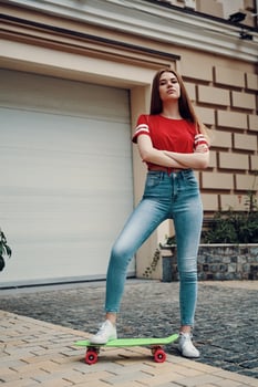 City style. Full length of attractive young woman keeping arms crossed while standing outdoors photo