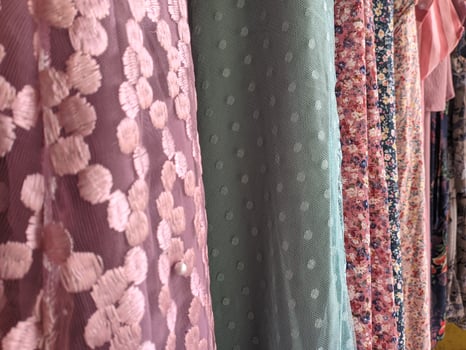 a collection of local women's clothing hanging and sold in traditional markets with various colors and motifs photo