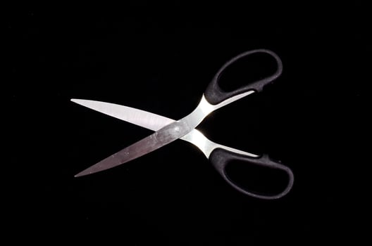Scissors on black background photo