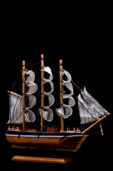 Toy ship on black background photo