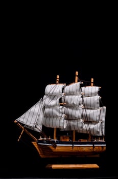 Toy ship on black background photo