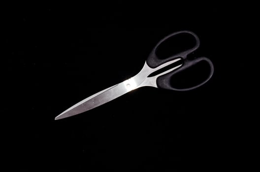 Scissors on black background photo